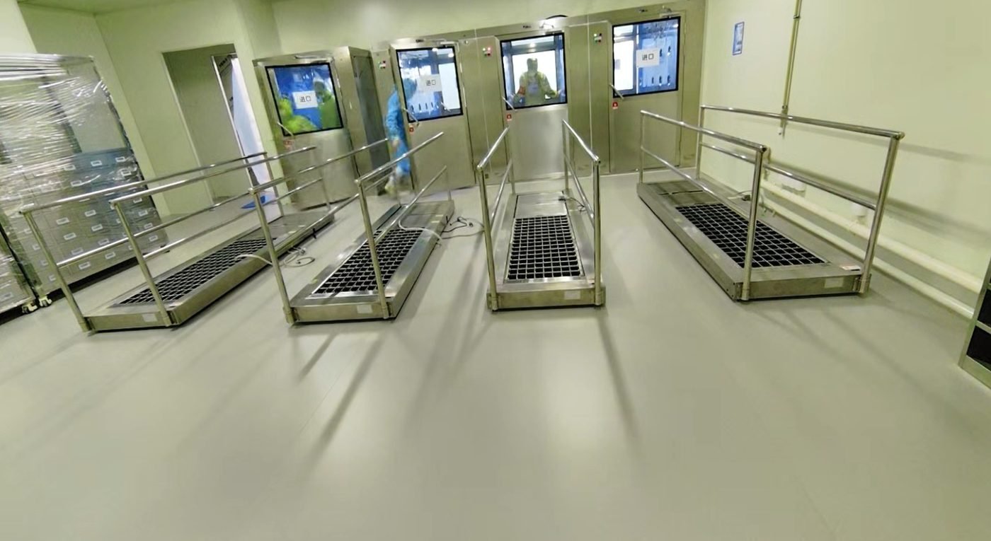 Four Klevo shoe sole cleaning machines installed side by side at a cleanroom gowning corridor